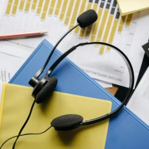 Close-up of an office desk with headset, charts, and documents showcasing customer service support.